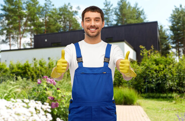 profession, cleaning service and building concept - happy smiling male worker or cleaner in overall...