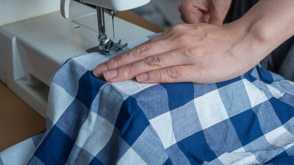 電動ミシンを操作する女性の手