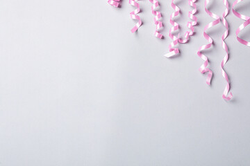 Pink serpentine streamers on light background, flat lay. Space for text