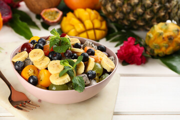 Delicious exotic fruit salad served on white table. Space for text