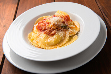 Piatto di ravioli di zafferano ripieni di ricotta con salsa di pomodoro e parmigiano, Cucina Italiana 