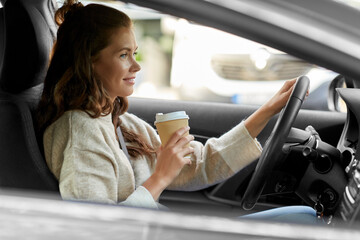 Fototapeta na wymiar lifestyle and people concept - happy smiling young woman or female driver driving car and drinking takeaway coffee