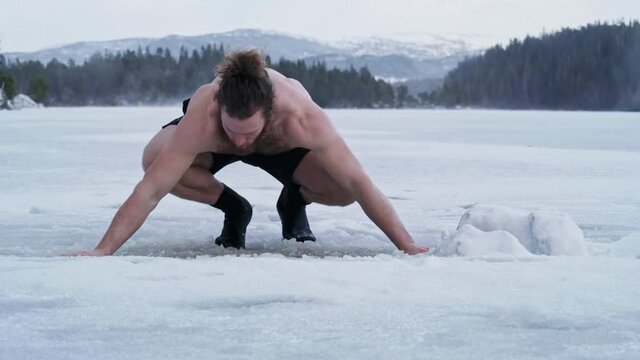 Fit Man Walks And Immerses Into The Ice Hole. Winter Swimming In Trondheim, Norway. medium shot