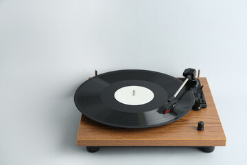Turntable with vinyl record on light background. Space for text