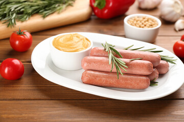 Delicious vegetarian sausages with rosemary and sauce on wooden table