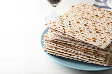 Plate with stack of matzos on white table