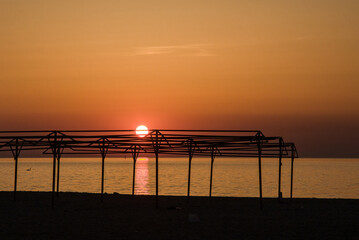 Fototapeta na wymiar Sun ball at sunset on the city beach