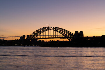 Silhouette of Sydney Harbour Bridge at dawn.
