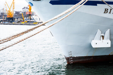 Odessa, UKRAINE - MART 1, 2021. A ship is moored at the pier in the port. Port cranes are working...