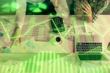 Double exposure of man and woman working together and financial graph hologram drawing. market analysis concept. Computer background. Top View.