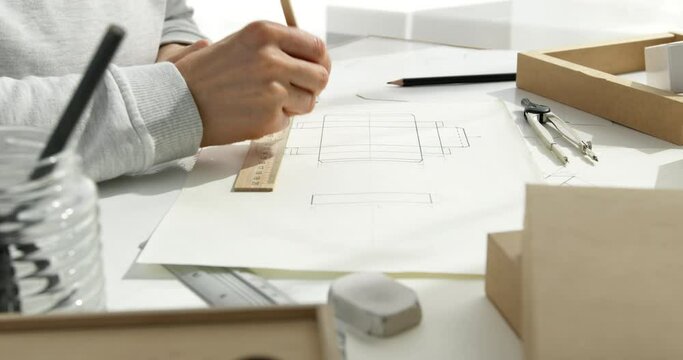 Designer draws a mockup for crafting eco cardboard box. Development a sketch of paper packaging.