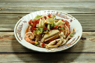 Traditional spicy mixed salad serving on the plate. Famous appetizer menu in Asian restaurant. 