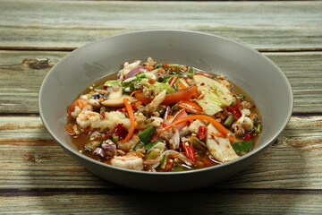 Traditional spicy mixed salad serving on the plate. Famous appetizer menu in Asian restaurant. 