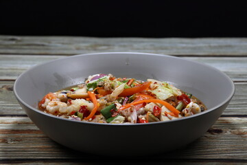 Traditional spicy mixed salad serving on the plate. Famous appetizer menu in Asian restaurant. 