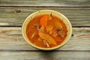 Traditional red curry soup of mixed fresh vegetable serving in the bowl. Famous spicy and sour soup menu in Asian restaurant. 
