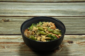 Traditional fried and stirred cutting Chinese zucchini mixed with egg and peeled shrimp serving in the bowl. Famous side dish menu in Asian restaurant. 