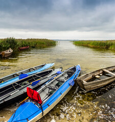 a three kayaks and some old wooden boats on the Pulemetske lake, Shatsk National Natural Park, Volyn region of Western Ukraine