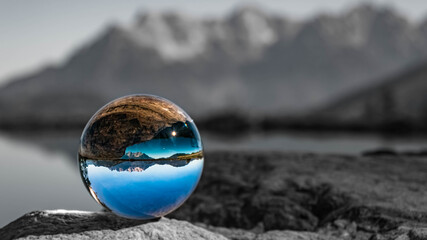 Crystal ball alpine landscape shot with black and white background outside the sphere at Fieberbrunn, Tyrol, Austria