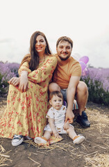 Dad and mom, parents play with their little son in a lavender field