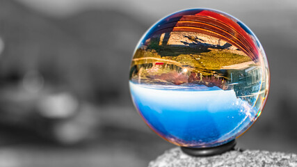 Crystal ball alpine landscape shot with black and white background outside the sphere at the famous Kampenwand, Aschau im Chiemgau, Bavaria, Germany
