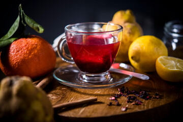 cup of fruit tea on a wooden table. red tea together with its ingredients seen from above