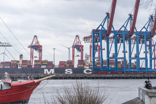 Hamburg, Germany - March 28, 2021: Mobile harbour cranes and MSC container ship at the Port of Hamburg, northern Germany