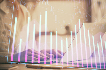 Double exposure of woman hands working on computer and forex graph hologram drawing. Financial analysis concept.