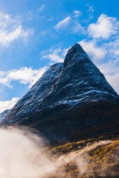 Mountain with fresh snow above mist
