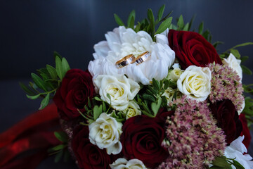 
wedding rings lie on the bride's bouquet
