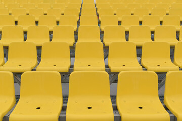 Fototapeta premium Rows of empty place in the stadium. Plastic seats in yellow.