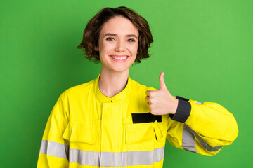 Photo of young woman firefighter happy positive smile show thumb-up like cool advert isolated over green color background