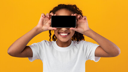 Black girl covering eyes with smartphone with blank empty screen