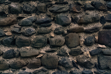 Black stones in the wall as an abstract background