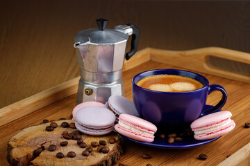 Cup of coffee, macaroons and coffee beans on a platter and geyser coffee maker on a wooden tray