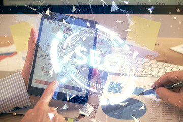 Multi exposure of man's hands holding and using a digital device and seo drawing. search optimization concept.
