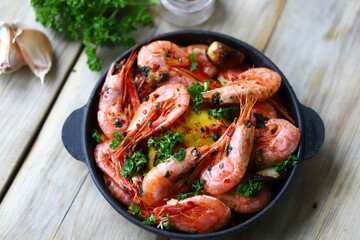 Shrimp in a frying pan. Fried flambé shrimps in shells with spices.