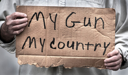 Man holding My Gun, My Country, handwritten cardboard sign, gun laws, second amendment rights, NRA, mass shootings, freedom, liberties