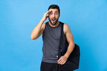 Naklejka premium Young sport man with sport bag isolated on blue background has realized something and intending the solution