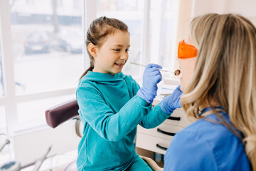 Child stomatologist with a patient at a dental clinic checking teeth. 