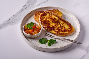Homemade traditional Spanish torrijas or French toast with melon candied fruit and mint on marble background. Popular dessert for Christmas, Easter or Pascua. Close up