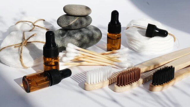 Reusable and recycable bathroom accessories on white background. Trendy shadows. Zero waste concept. Natural cosmetics and eco living concept. Essential oil or serum
