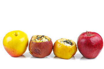 Yellow and red fresh and stuffed baked apples with sezame seeds and walnuts isolated on a white background