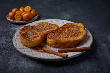 Homemade traditional Spanish torrijas or French toast with sugar and cinnamon on dark background. Popular dessert for Christmas, Easter or Pascua. Selective focus, close up