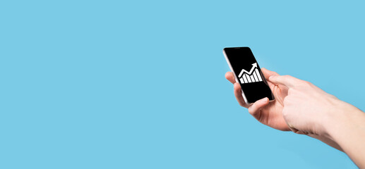 Male hand holding smart mobile phone with graph icon.checking analyzing sales data growth graph chart and stock market on global networking. Business strategy, planning and digital marketing