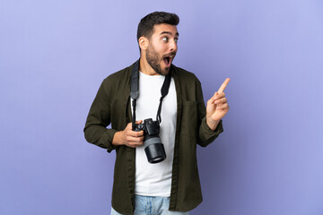 Photographer man over isolated purple background intending to realizes the solution while lifting a finger up