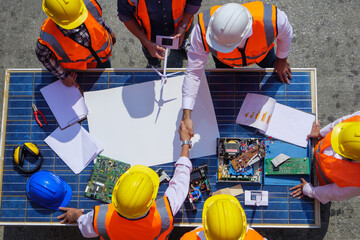 Holding hands top view of Architectural engineers working on solar panel and his blueprints with...