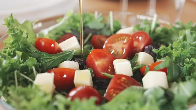 イタリアンサラダにオリーブオイルをかける