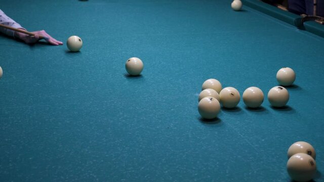 Game of billiards. White balls roll on green cloth.
