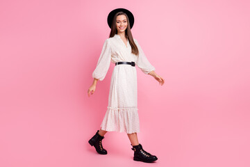 Photo of adorable pretty young woman dressed white clothes cap walking isolated pink color background