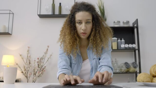 Female freelancer typing on laptop, working remotely from home, journalist